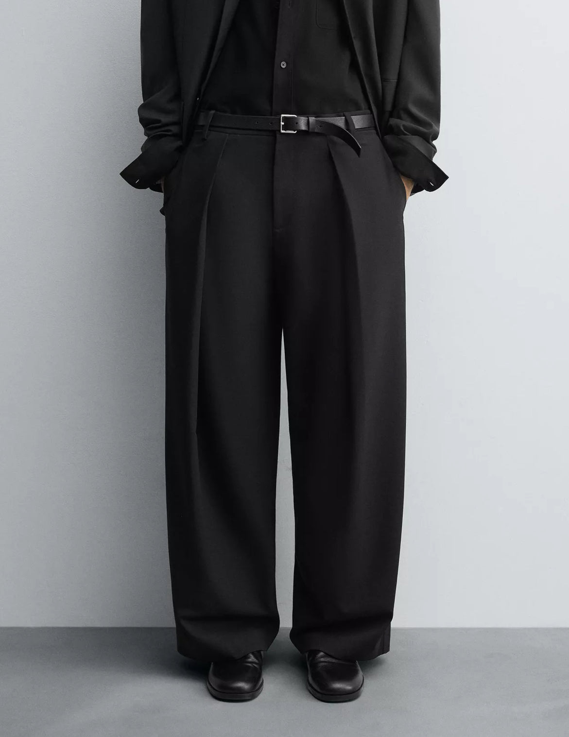 Czarne, eleganckie spodnie z zakładami z wełny.