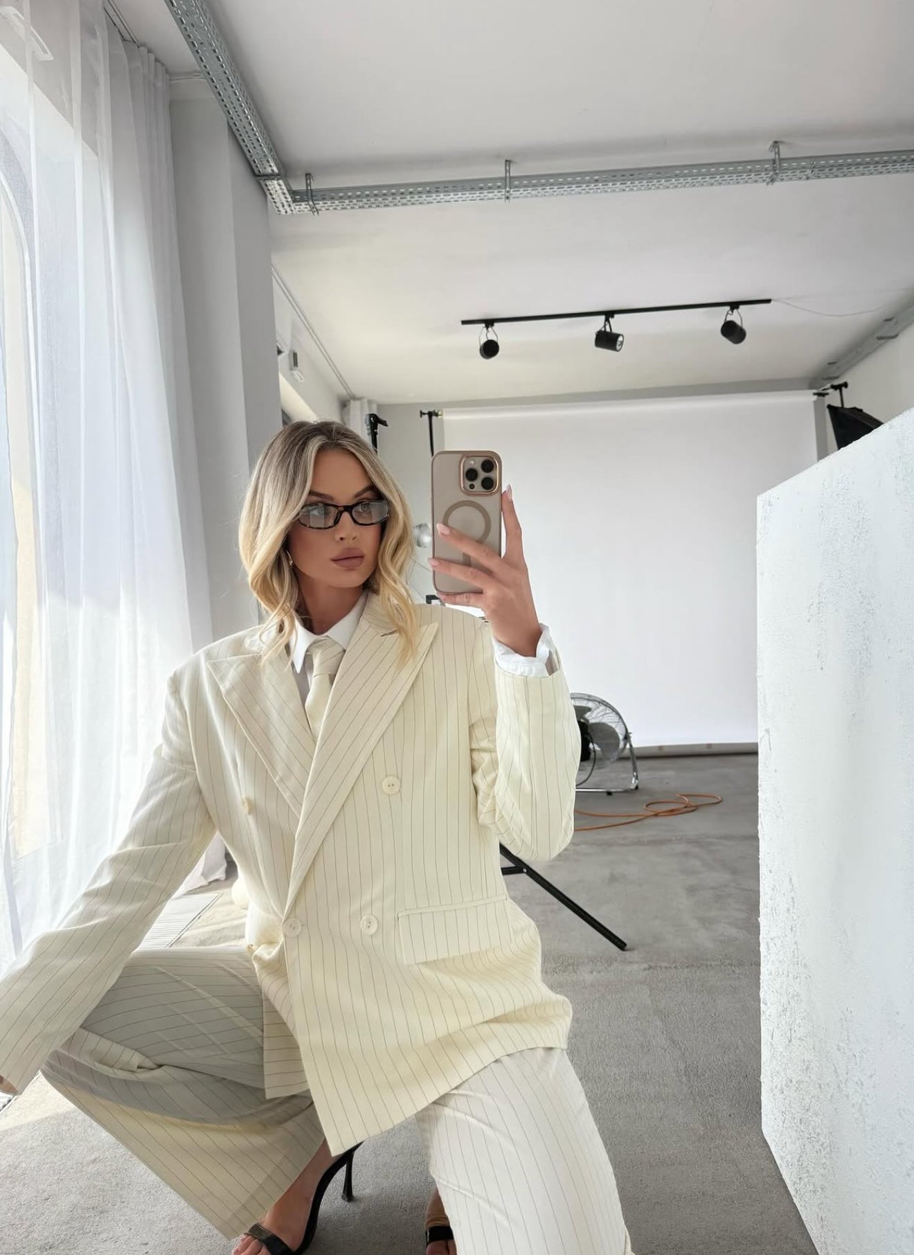 Kremowy garnitur damski w prążek z krawatem. Marynarka i spodnie