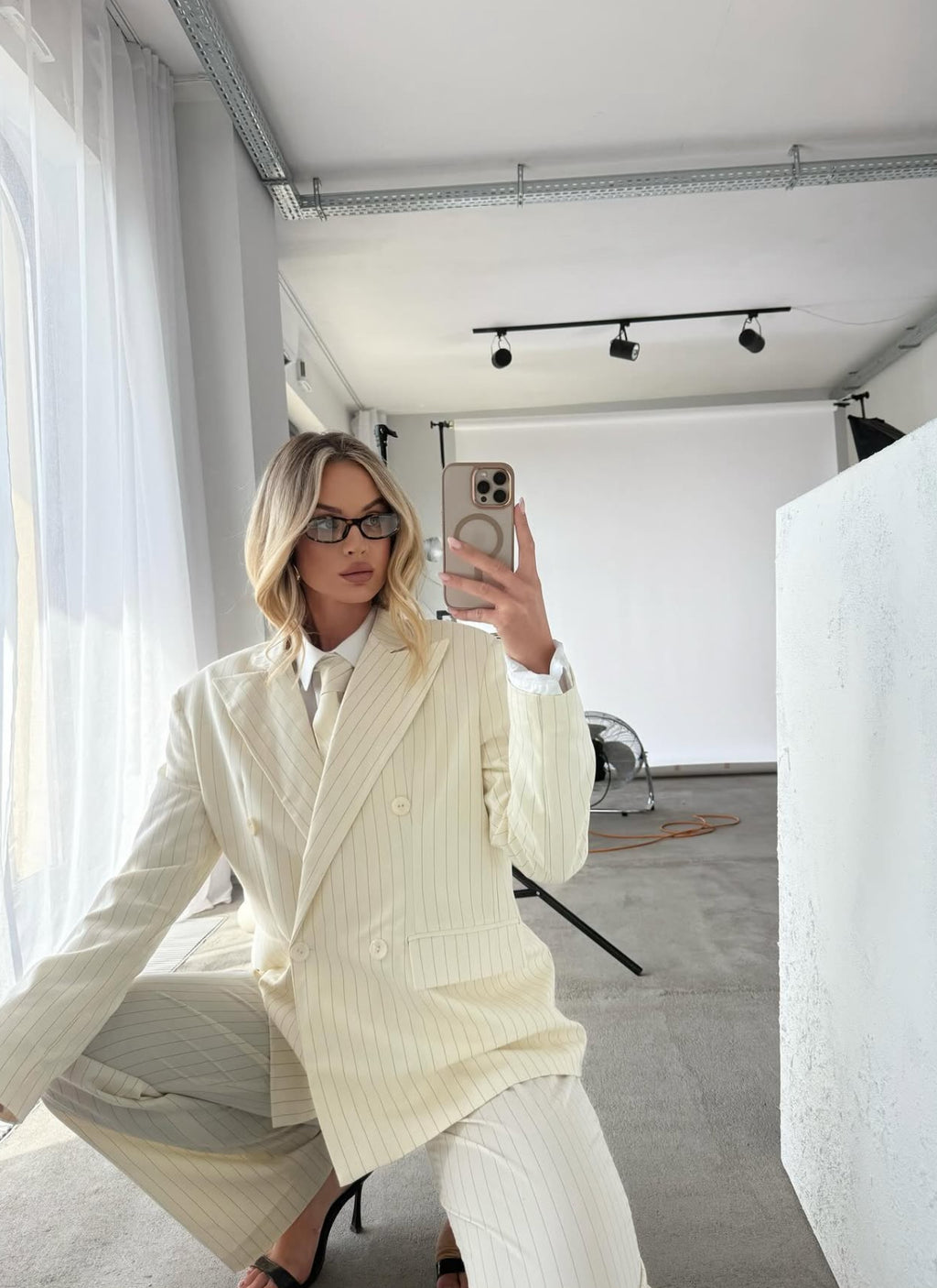 Kremowy garnitur damski w prążek z krawatem. Marynarka i spodnie